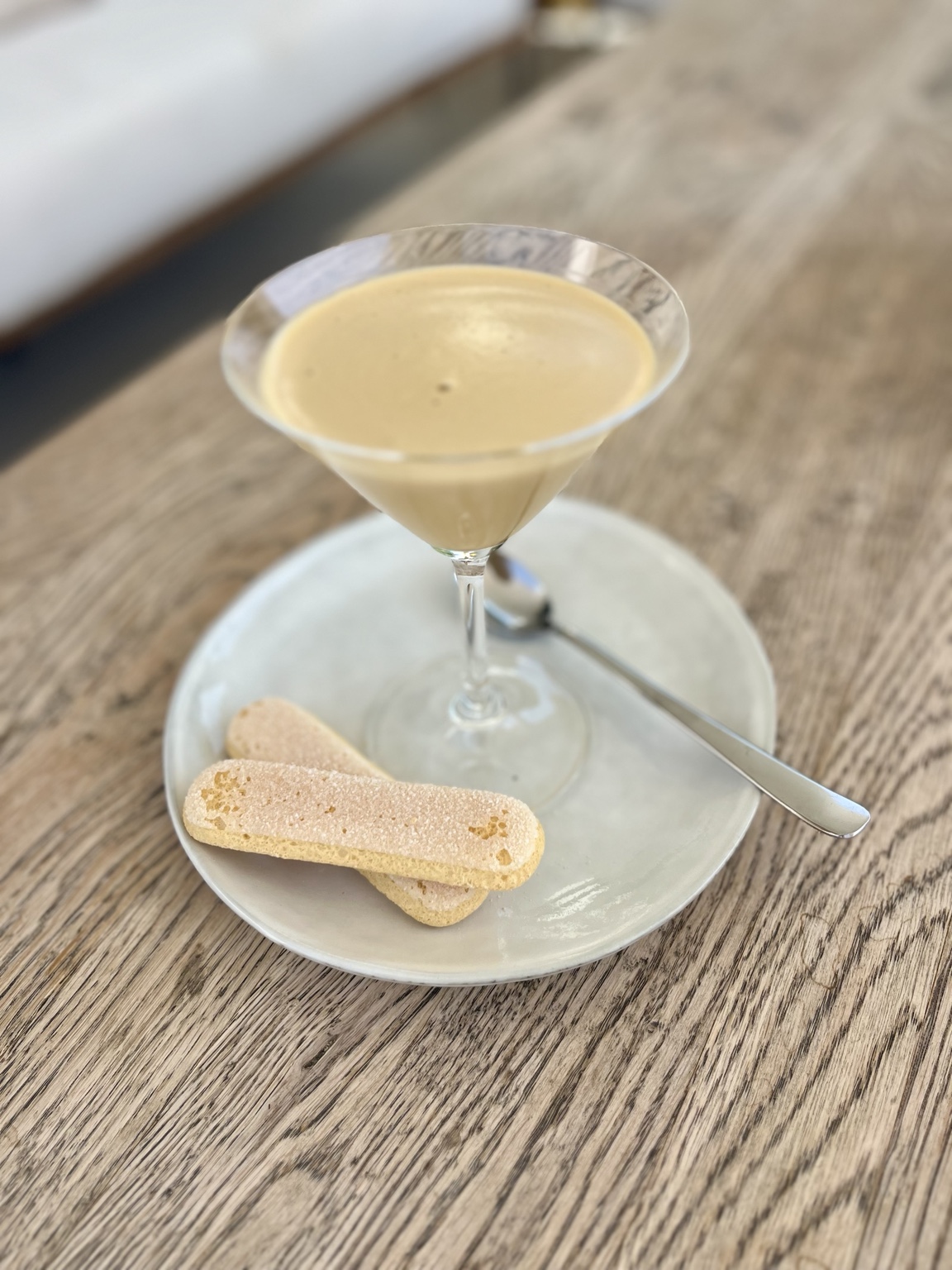 A creamy dessert served in a glass with biscuits